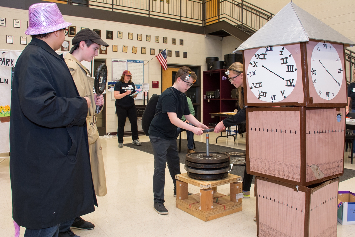 Students performing at a tournament, putting weights on their structure